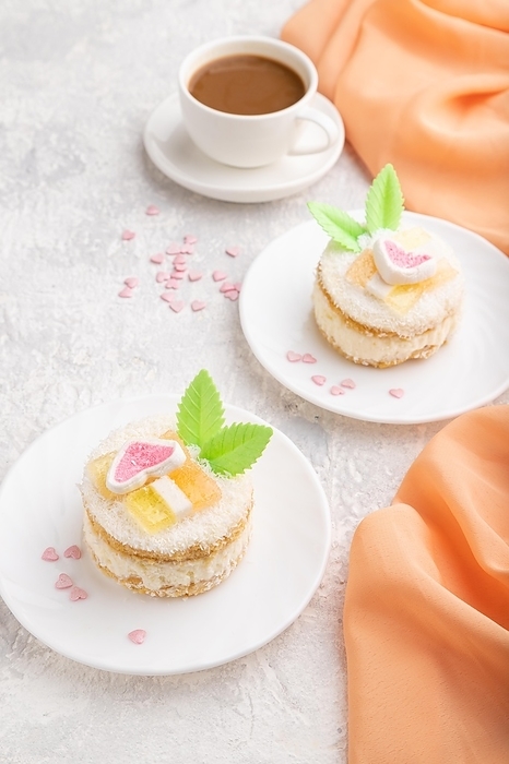 Decorated cake with milk and coconut cream with cup of coffee on a gray concrete background and orange textile. Side view, close up, by ULADZIMIR ZGURSKI