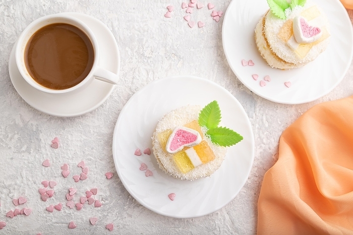 Decorated cake with milk and coconut cream with cup of coffee on a gray concrete background and orange textile. top view, flat lay, close up, by ULADZIMIR ZGURSKI