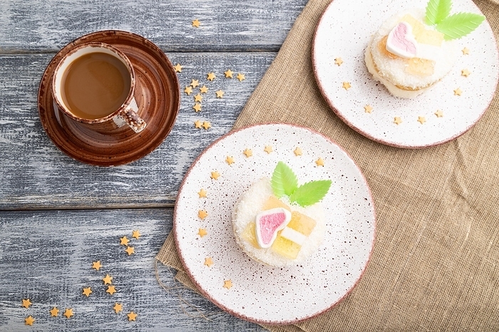 Decorated cake with milk and coconut cream with cup of coffee on a gray wooden background and linen textile. top view, flat lay, close up, by ULADZIMIR ZGURSKI