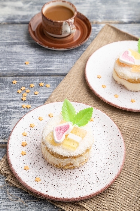 Decorated cake with milk and coconut cream with cup of coffee on a gray wooden background and linen textile. Side view, close up, by ULADZIMIR ZGURSKI