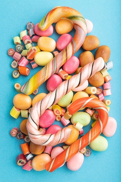 Various caramel candies on blue pastel background. close up, top view, flat lay, by ULADZIMIR ZGURSKI