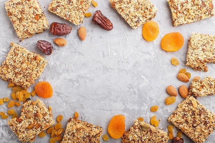 Homemade granola from oat flakes, dates, dried apricots, raisins, nuts with a cup of coffee on a gray concrete background. Top view, flat lay, copy space, frame form, by ULADZIMIR ZGURSKI