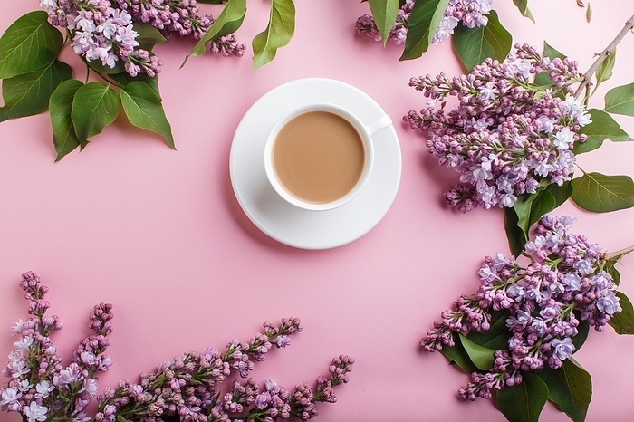 Purple lilac flowers and a cup of coffee on pastel pink background. Morninig, spring, fashion composition. Flat lay, top view, by ULADZIMIR ZGURSKI