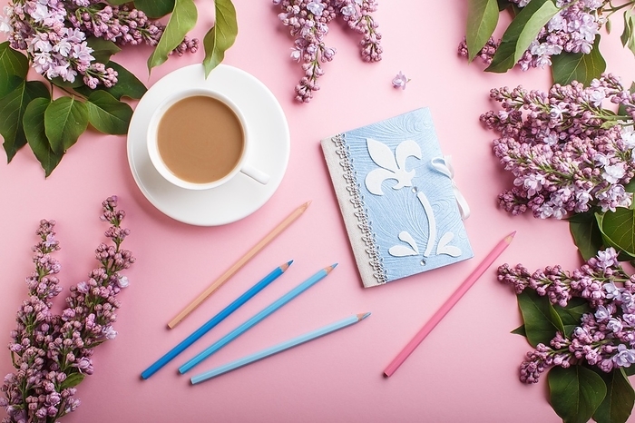 Purple lilac flowers and a cup of coffee with notebook and colored pencils on pastel pink background. Morninig, spring, fashion composition. Flat lay, top view, by ULADZIMIR ZGURSKI