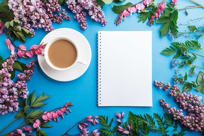 Purple lilac and bleeding heart flowers and a cup of coffee with notebook and colored pencils on pastel blue background. Morninig, spring, fashion composition. Flat lay, top view, by ULADZIMIR ZGURSKI