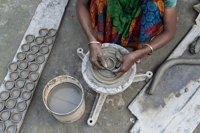 India BARPETA, INDIA, NOVEMBER 7: A woman makes earthen lamps or Diyas at her residence ahead of the Diwali Festival in a village in Barpeta, India on November 7, 2023. Earthen lamps are a significant part of Indian culture and tradition, by David Talukdar