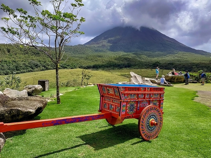 Costa Rica Arenal Volcano National Park, Costa Rica, A painted Costa Rican oxcart  carreta  below the Arenal volcano. The oxcart is important in Costa Rican history, used to transport coffee and other products. Today the oxcart is one of the countrys national symbols, Central America, by Jim West