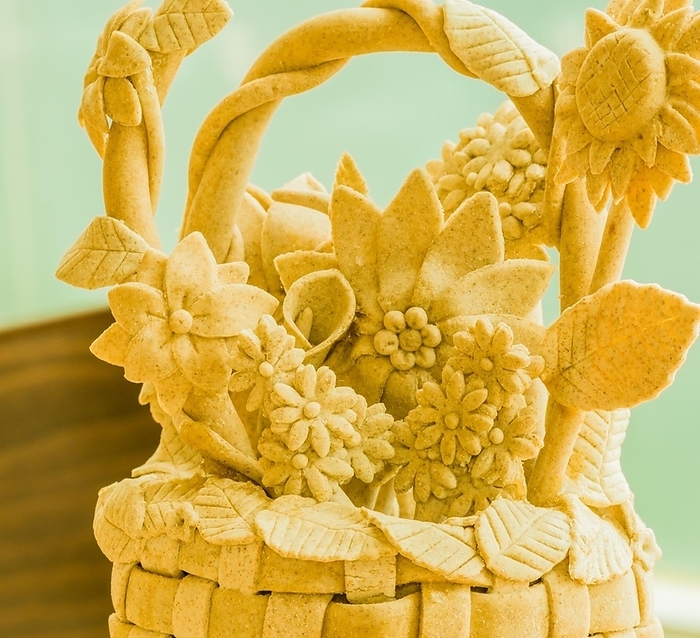 Handcrafted beige sculpture of a floral basket with detailed leaves, Teig, gebacken, by John Erskin