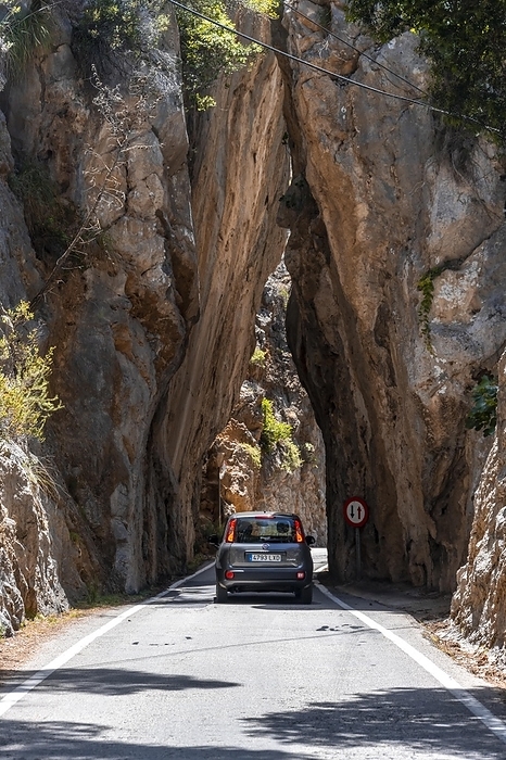 Spain Car at a tunnel of rocks at the mountain pass to Sa Colobra, Serra de Tramuntana, Majorca, Balearic Islands, Spain, Europe, by Moritz Wolf