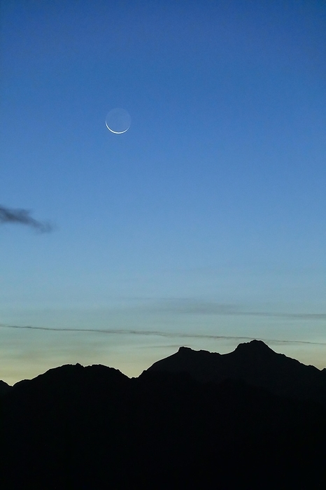 Switzerland Crescent moon over mountain silhouette, Valais, Swiss Alps, by Patrick Frischknecht
