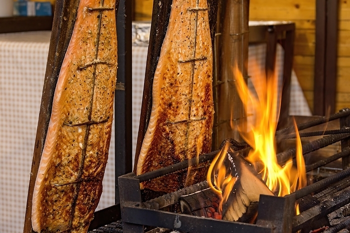 Germany Flame grilled salmon in a fire bowl, fillets of salmon grilled over an open flame, fish cooked, speciality from Finland, Leumulohi, snack bar, market stall, folk festival Kalter Markt, Kaale M  rt, funfair, fairground, Ortenberg, Wetterau, Hesse, Germany, Europe, by Raimund Kutter