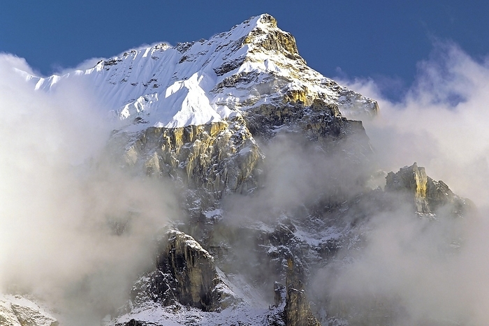 Nepal Afternoon mist and clouds gather around the dramatic crags and summit of an un named peak in the Kangchenjunga region of east Nepal, by Klaus Steinkamp