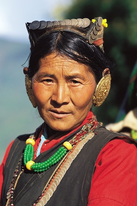 Nepal Sherpa woman at Dasaain festival in Seduwa village in the Makalu region of east Nepal. The solid gold earrings and silver coins around her neck and on her headdress would have been her dowry when she married, by Klaus Steinkamp