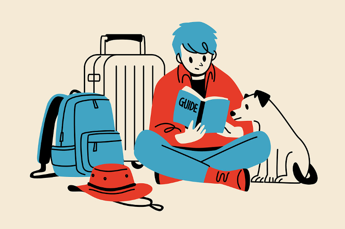A man and his pet looking at a guidebook on a trip