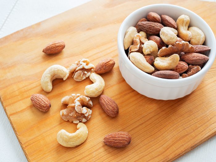 Almonds, walnuts, and cashews on a cutting board
