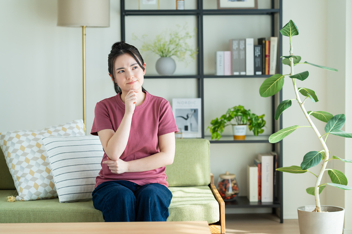 Young Japanese woman distressed in her living room.