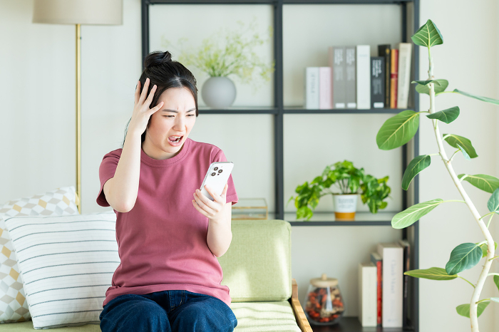 Young Japanese woman troubled by her cell phone (People)