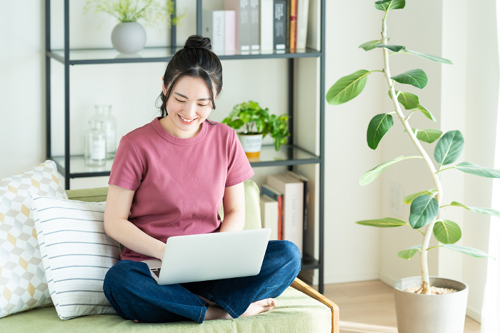 Young Japanese woman using computer in living room (People)