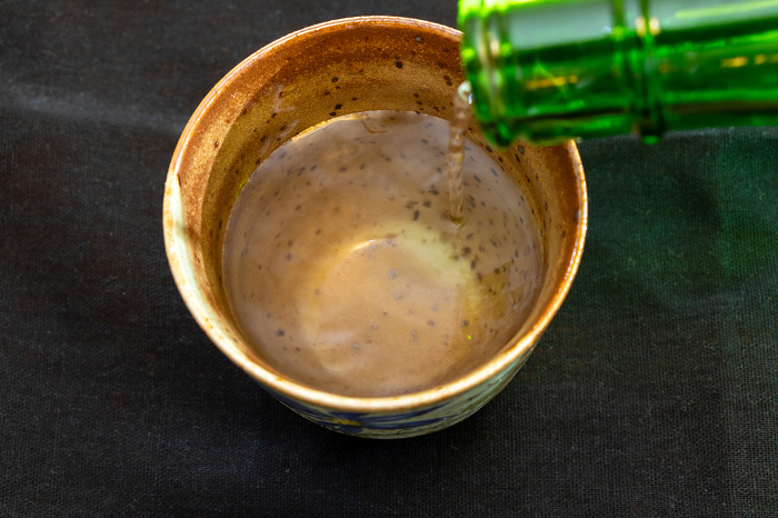 Pour sake into a ceramic cup