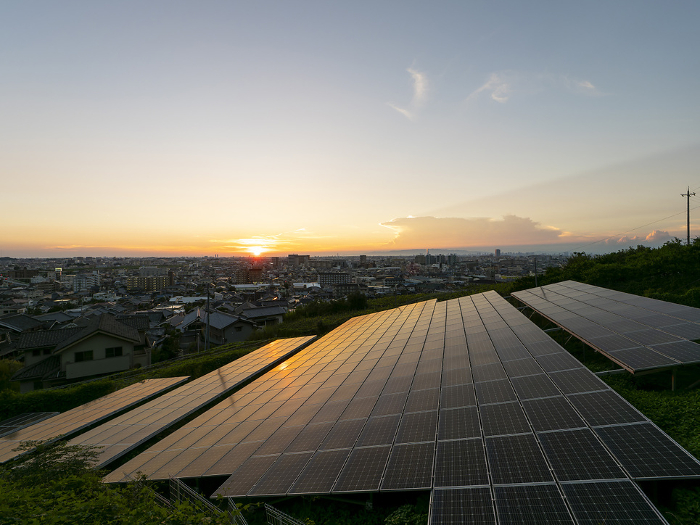 Photovoltaic power generation equipment installed in the mountains and the cityscape at dusk