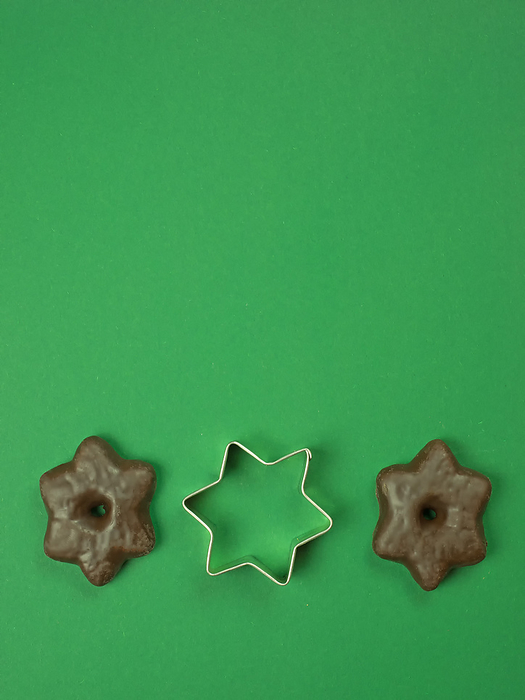 Christmas background from star and gingerbread isolated on green Christmas background from star and gingerbread isolated on green, by Zoonar Katrin May