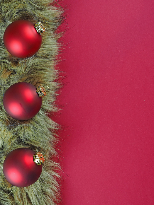 Christmas background from red baubles on fur isolated on red Christmas background from red baubles on fur isolated on red, by Zoonar Katrin May