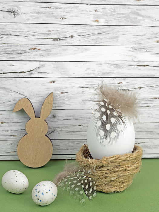Easter background with Easter eggs and Easter bunny isolated on green in front of wood Easter background with Easter eggs and Easter bunny isolated on green in front of wood, by Zoonar Katrin May