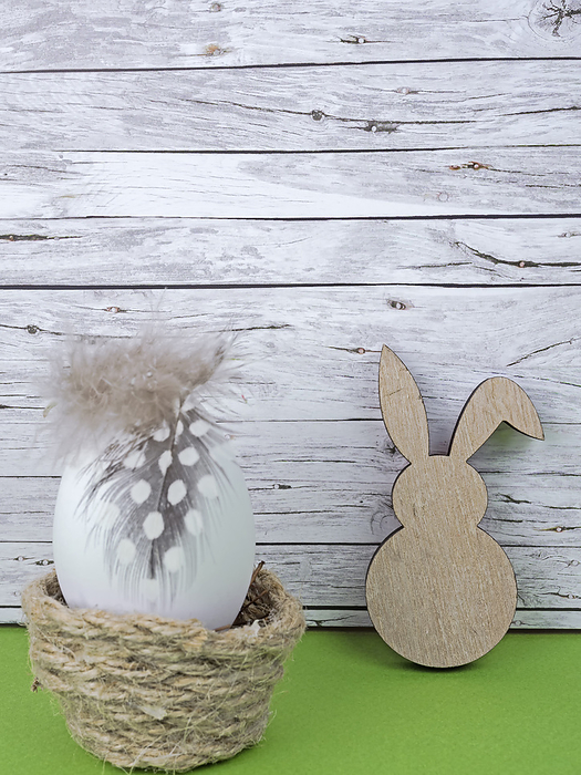 Easter background with Easter egg and Easter bunny isolated on green in front of wood Easter background with Easter egg and Easter bunny isolated on green in front of wood, by Zoonar Katrin May