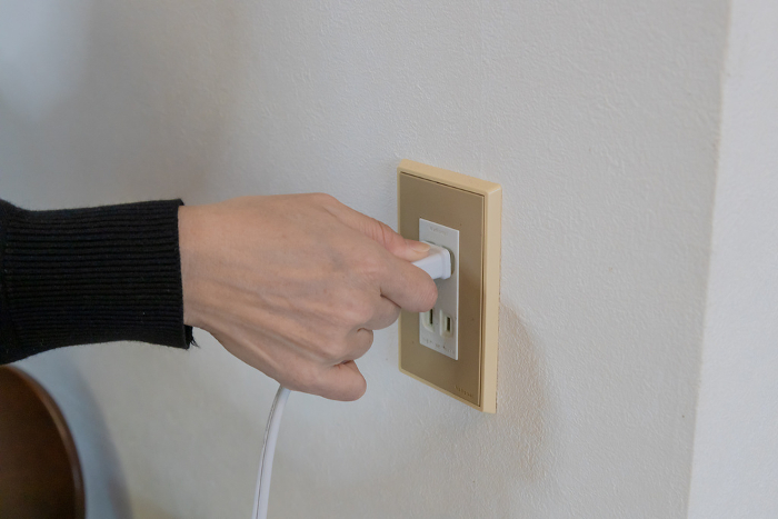 Hand plugged into an outlet