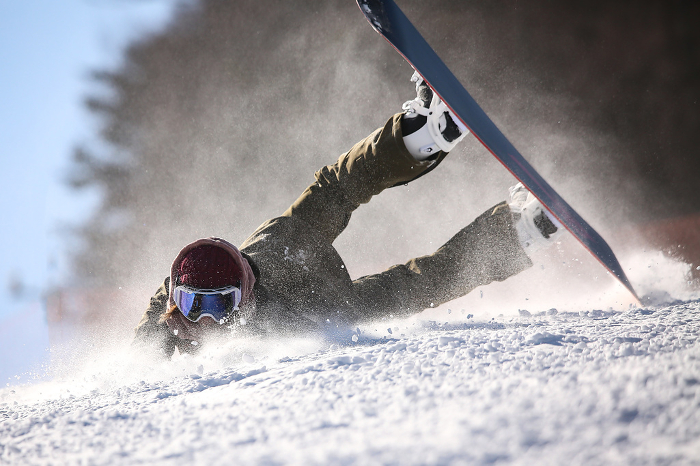 Female snowboarder falling down