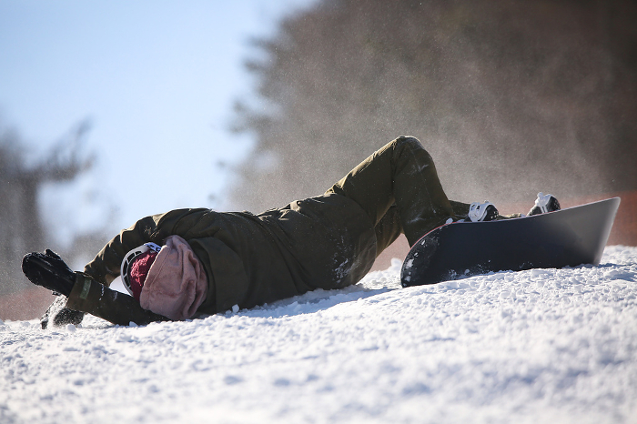 Female snowboarder falling down
