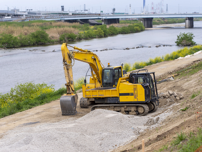 Hydraulic excavators and carrier dump trucks at construction sites
