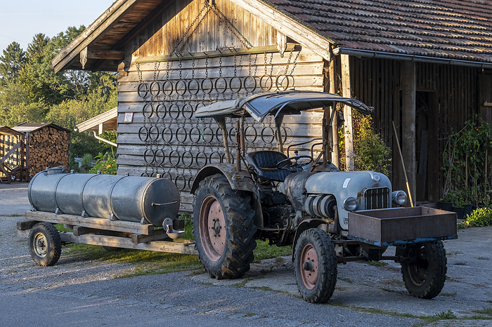 Old tractor with manure barrel as a cattle road Old tractor with manure barrel as a cattle road, by Zoonar Anna Reinert