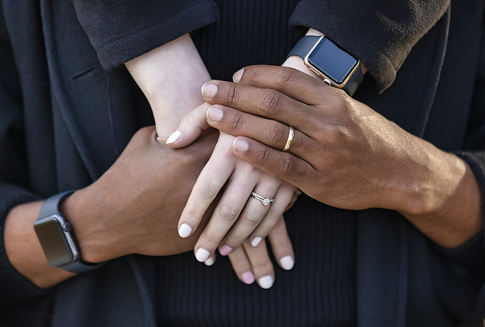 LJMZZ41642  Stevon Artis ,LJMZZ41643  Kayla Kimo  Close up of the interlocked hands of a mixed race couple, spending quality time together during a fall family outing in a city park  Edmonton, Alberta, Canada, by LJM Photo   Design Pics