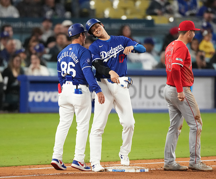 2024 MLB Open Game Ohtani touches helmets with first base coach Shohei Ohtani  center  touches helmets with the first base running coach after drawing a walk with two outs in the bottom of the fifth inning for the Dodgers against the Angels, March 25, 2024.