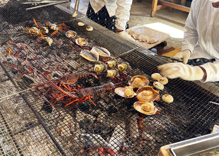 Ama divers grilling fresh lobsters, shellfish, and fish over charcoal in their huts. Mie, Japan