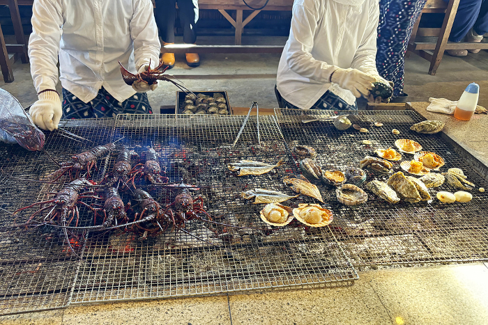 Ama divers grilling fresh lobsters, shellfish, and fish over charcoal in their huts. Mie, Japan