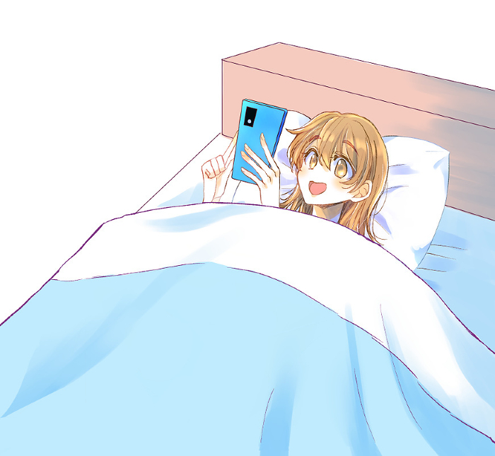 Woman laughing at her phone in bed