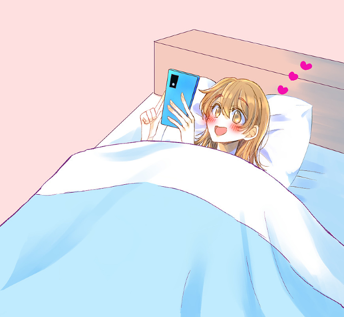 Woman smiling at her phone in bed Love