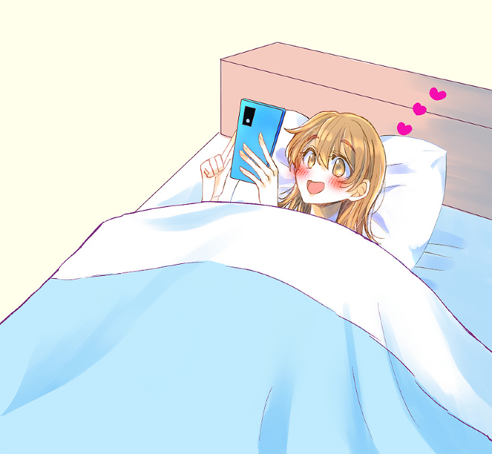 Woman smiling at her phone in bed Love