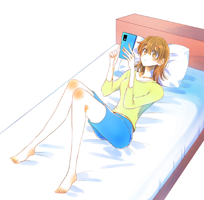 Woman looking at her phone on the bed