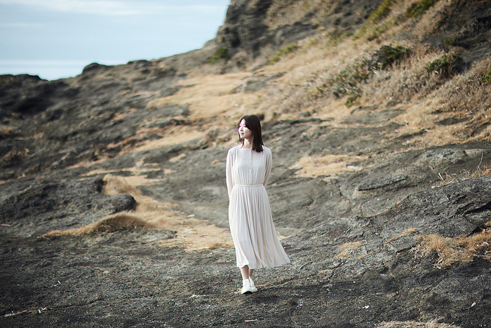 Japanese woman walking on the road leading to the sea