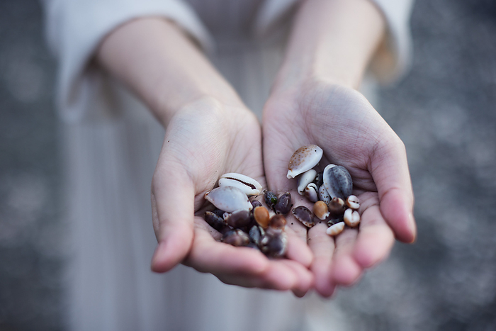 A Japanese woman's hand picking up shells