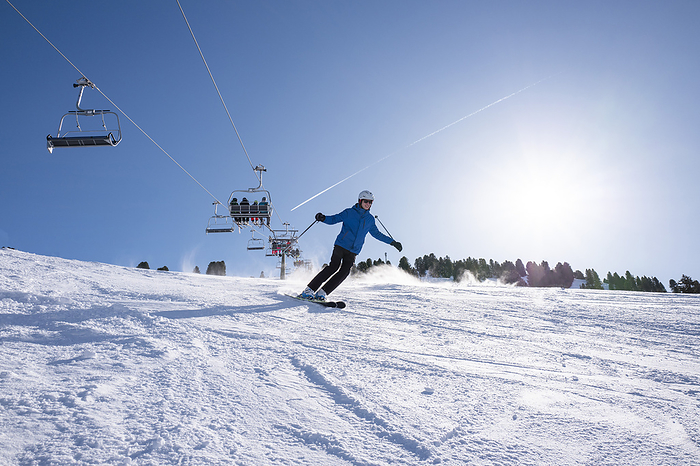 wintersport Adventurous man skiing down a slope in winter gear.