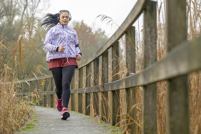 Jonge vrouw gaat sporten op haar vrije ochtend Healthy fit woman running through the park keeping fit