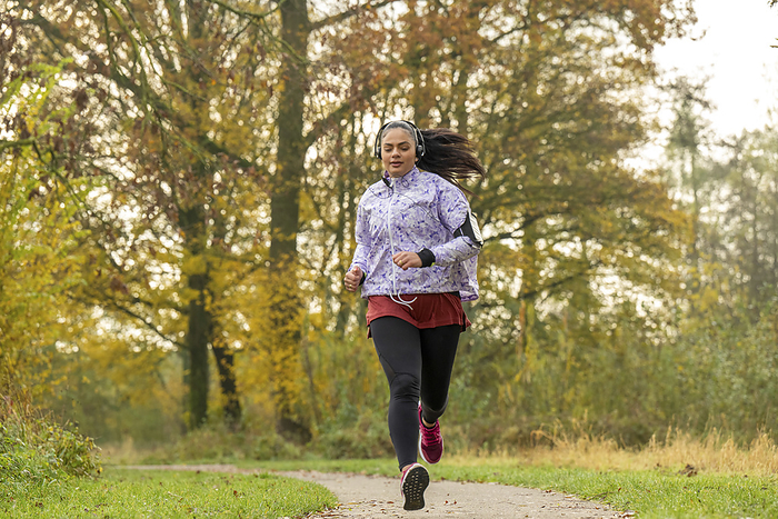 Jonge vrouw gaat sporten op haar vrije ochtend Healthy fit woman running through the park keeping fit
