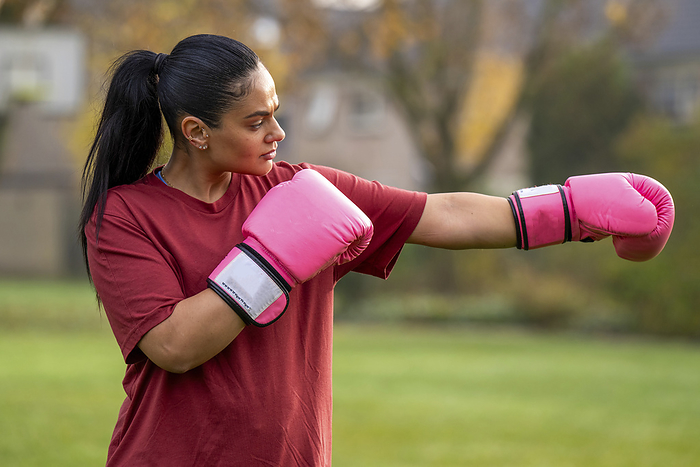 Jonge vrouw gaat sporten op haar vrije ochtend Healthy woman boxing training in a public park