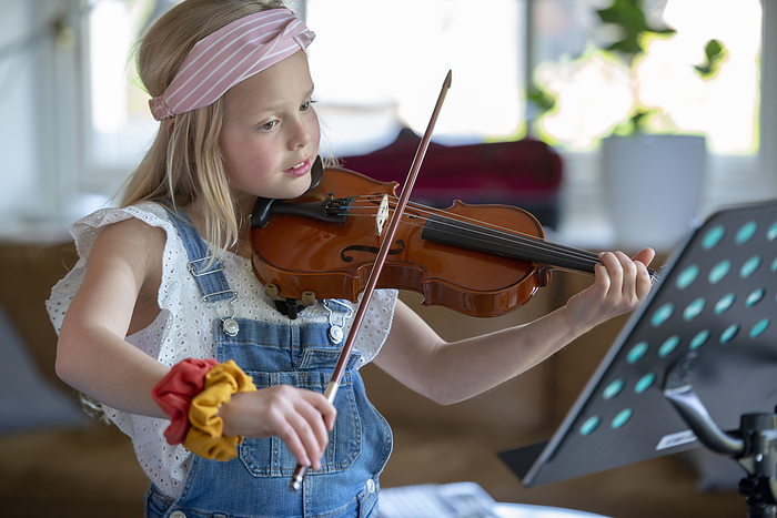 meisje oefent op haar viool Young teenage girl playing violin, practising her new music.
