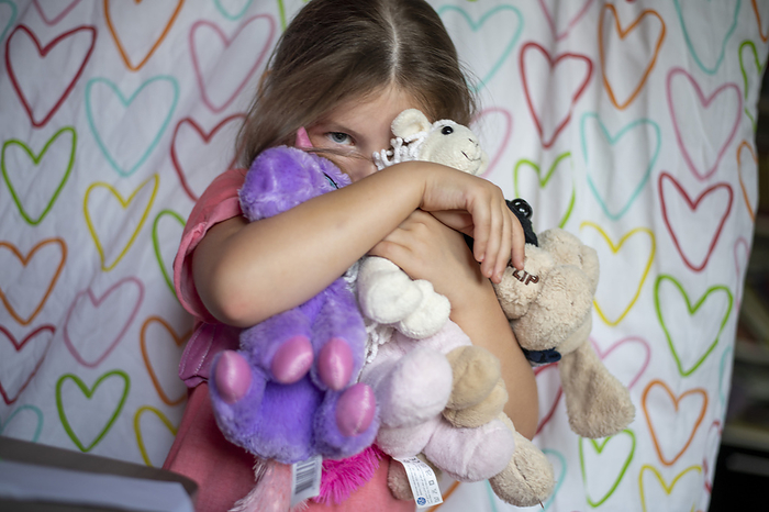kinderen bedtijd Young girl being shy hugging her teddies for comfort