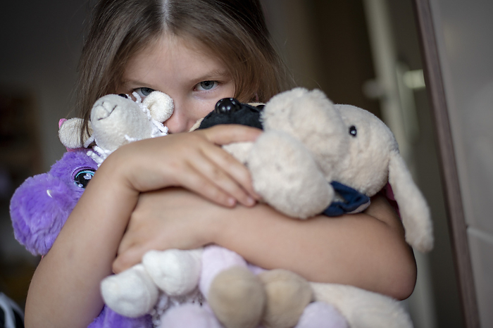 kinderen bedtijd Young girl being shy hugging her teddies for comfort